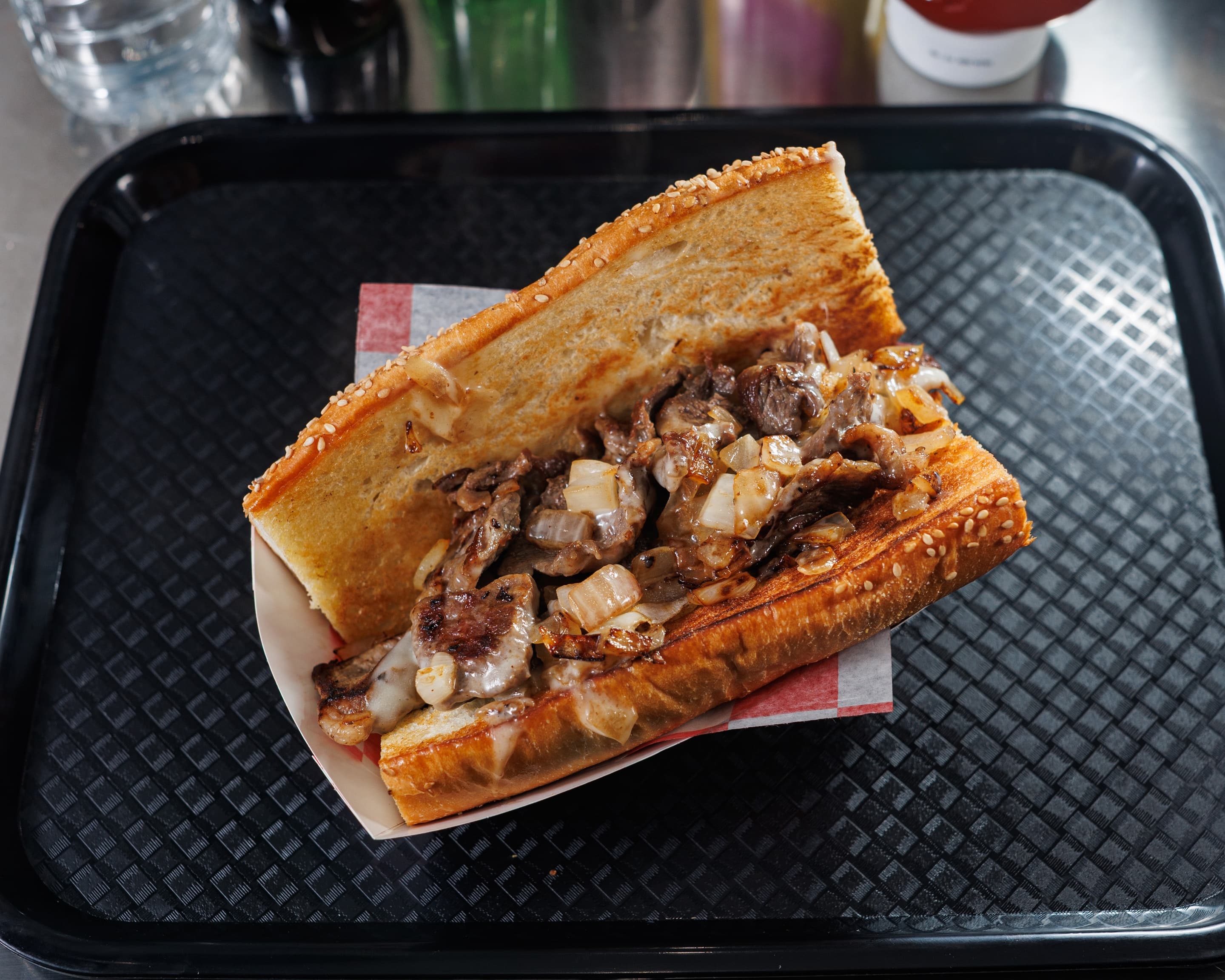 Philly cheesesteak with hand-carved ribeye, caramelized onions and melted Cooper Sharp on a seeded Italian hero